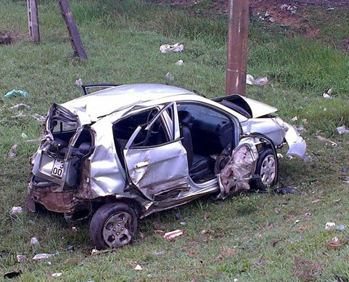 Chiếc xe ô tô bị biến dạng sau khi tông vào người điều khiển xe máy, cột mốc và biển báo.